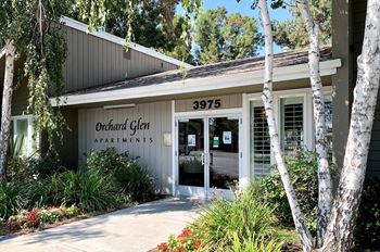 The front of a building with the number 3975 and the words Orchard Cliff Apartments on it.